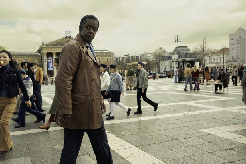 Dane (Adrian Lester) walks on a busy street on Ponies Episode 104.