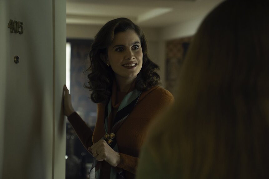 Cheryl (Vic Michelis) stands in a doorway on Ponies Episode 104.