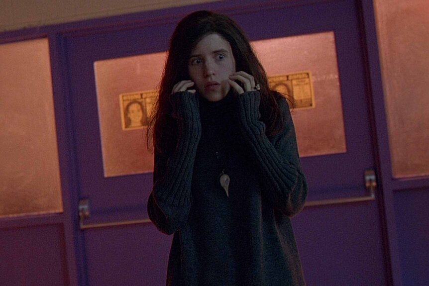 Brigitte Fitzgerald (Emily Perkins) walks through a hallway cautiously on&nbsp;Ginger Snaps (2000).
