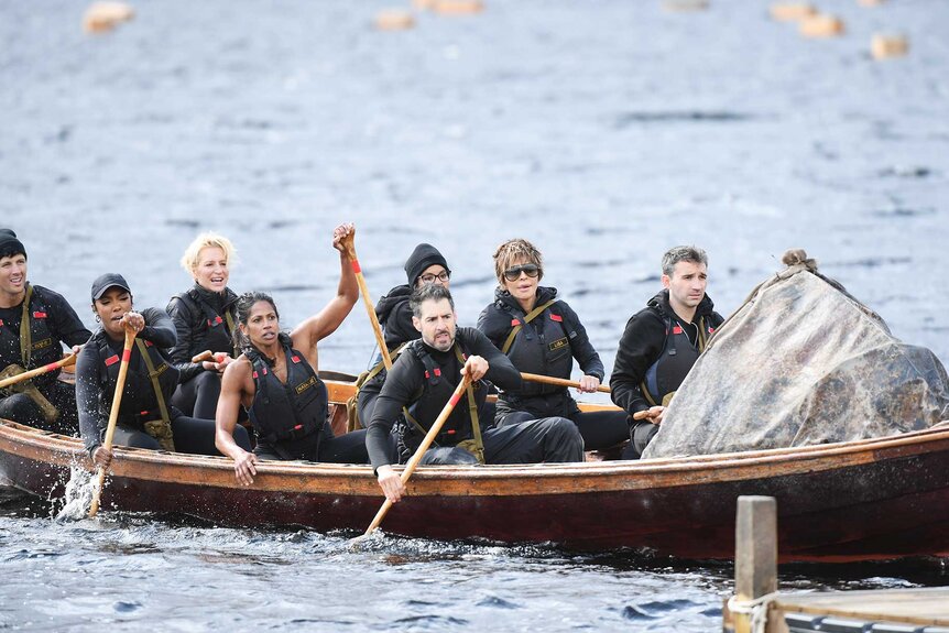 Rob Rausch, Porsha Williams, Dorinda Medley, Natalie Anderson, Tiffany Mitchell, Rob Cesternino, Lisa Rinna, and Ian Terry rowing a boat on The Traitors Season 4 Episode 1.