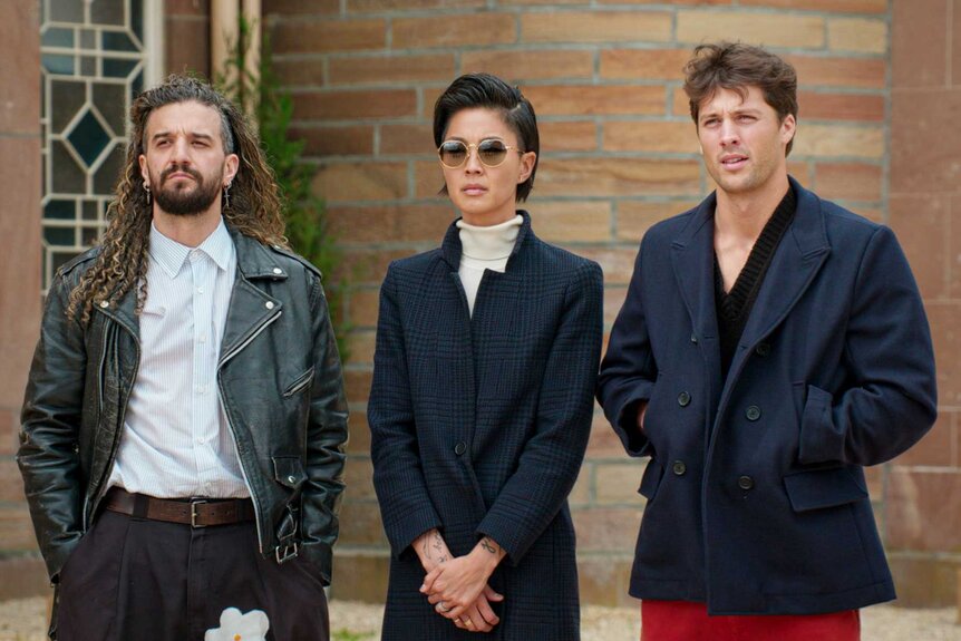 Mark Ballas, Kristen Kish, and Rob Rausch standing next to each other on The Traitors Season 4 Episode 8.