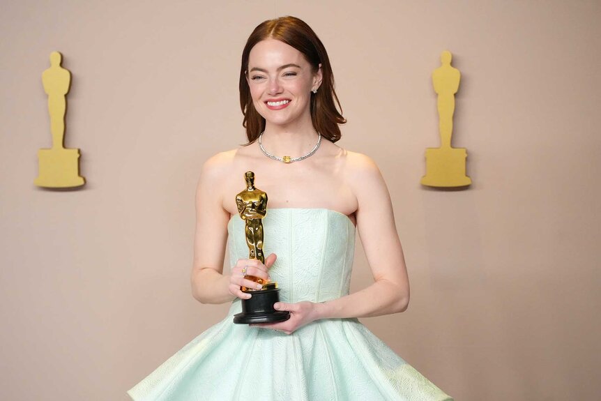 Emma Stone holding her Oscar in the press room at the 96th Annual Academy Awards.