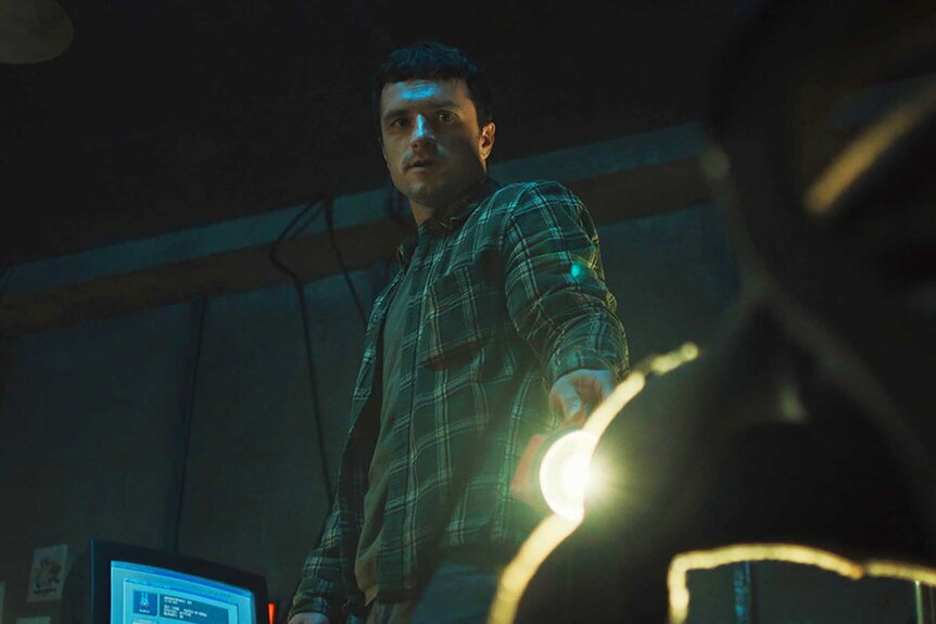 Mike looking down at a animatronic head in Five Nights at Freddy's (2025).