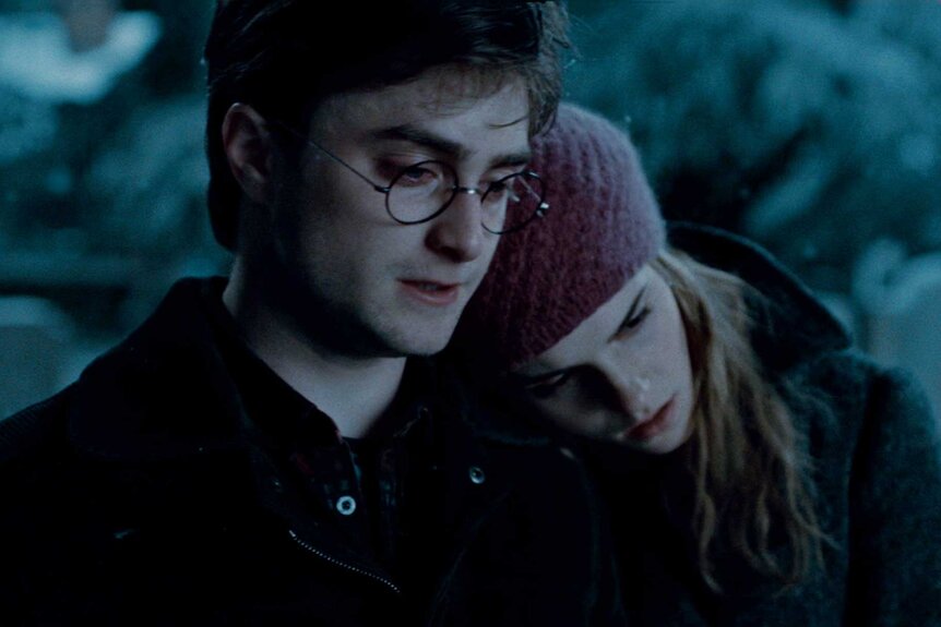 Harry Potter sitting with Hermione Granger in Harry Potter and the Deathly Hallows: Part 1 (2010).