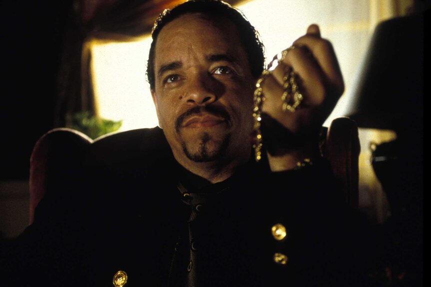 Mack Daddy holding a chain in Leprechaun In The Hood (2000).