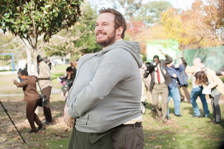 Andy Dwyer shoves another person under his jacket in Parks and Recreation Season 6 Episode 15.