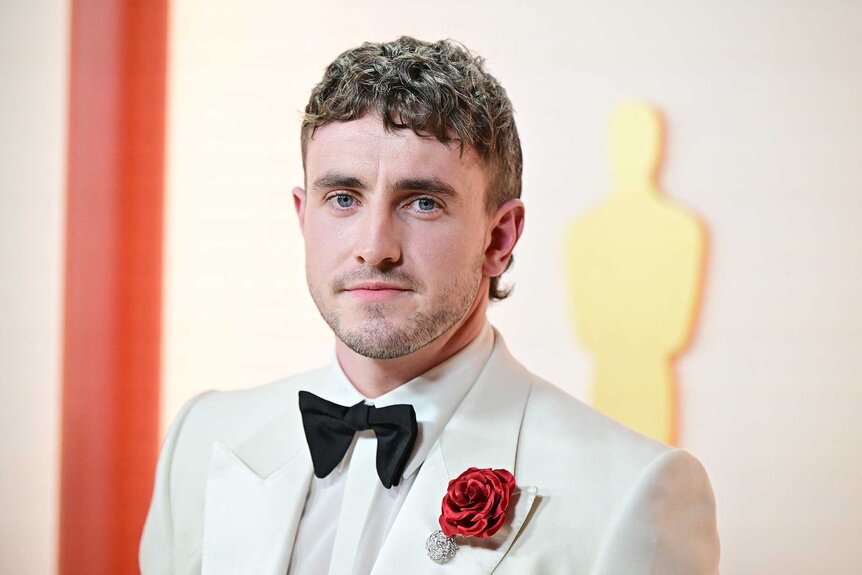 Paul Mescal in a white blazer with a red rose at the 95th Annual Academy Awards.
