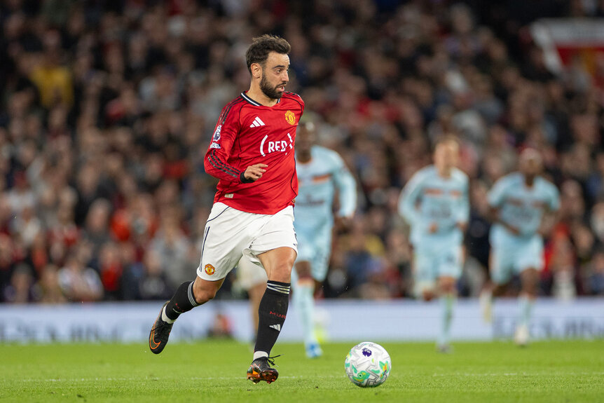 Bruno Fernandes on a soccer field during a game kicking a soccer ball.