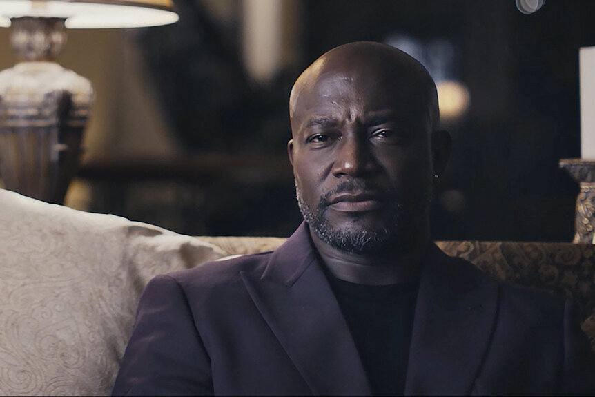 Taye Diggs sits on a sofa in Another Man's Wife (2026).