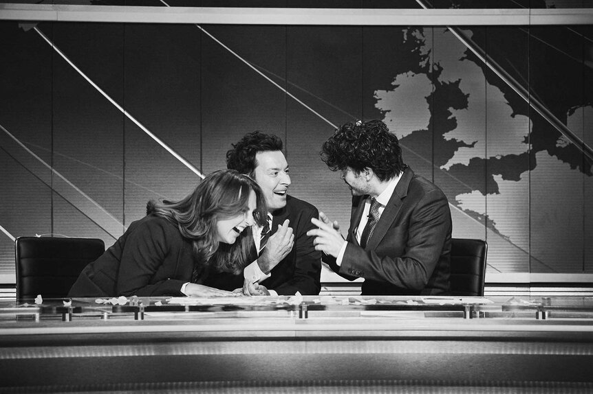 Ania Magliano hugging Jimmy Fallon while sitting with Paddy Young during Saturday Night Live UK Show 5.