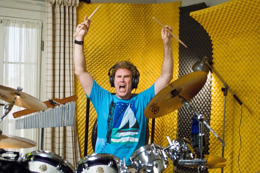 Brennan Huff playing the drums with his arms up in Step Brothers (2008).