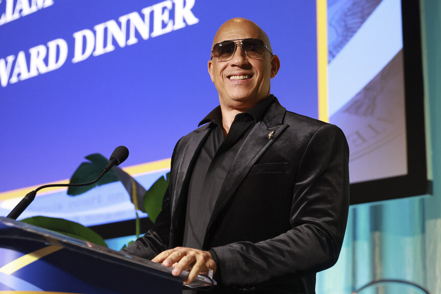 Vin Diesel smiling on stage at an event.