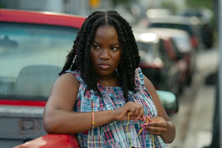 Lovely leans outside of a red truck in M.I.A. Season 1.