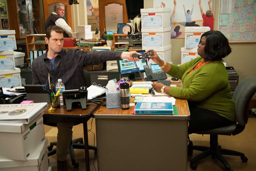 Craig and Donna Meagle holding a phone in Parks and Recreation Season 6 Episode 4.