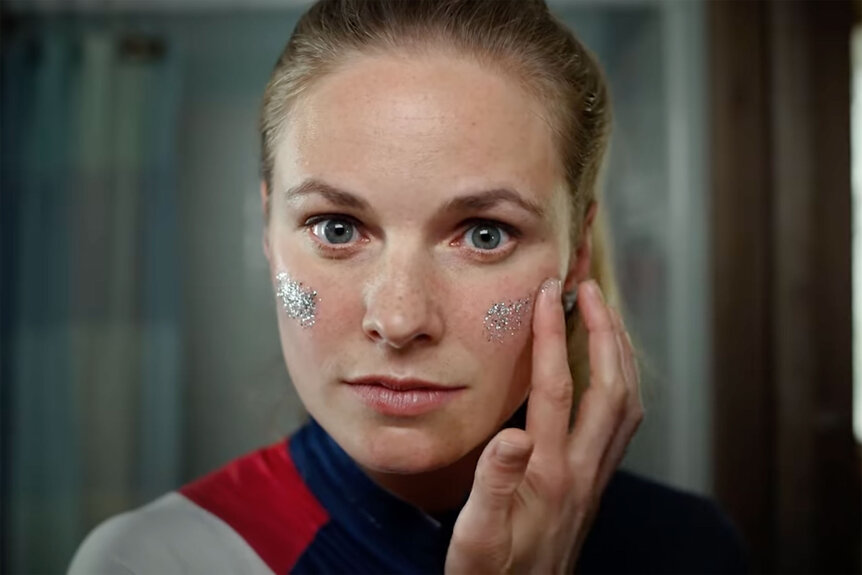 Jessie Diggins applying face glitter in Threshold (2026).