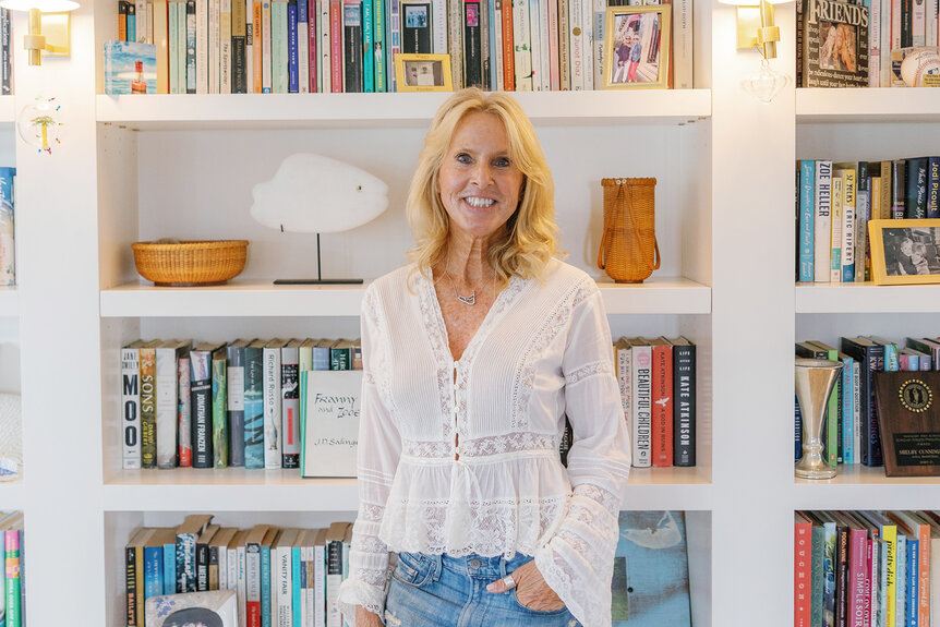 Elin Hilderbrand standing in front of her home Library.