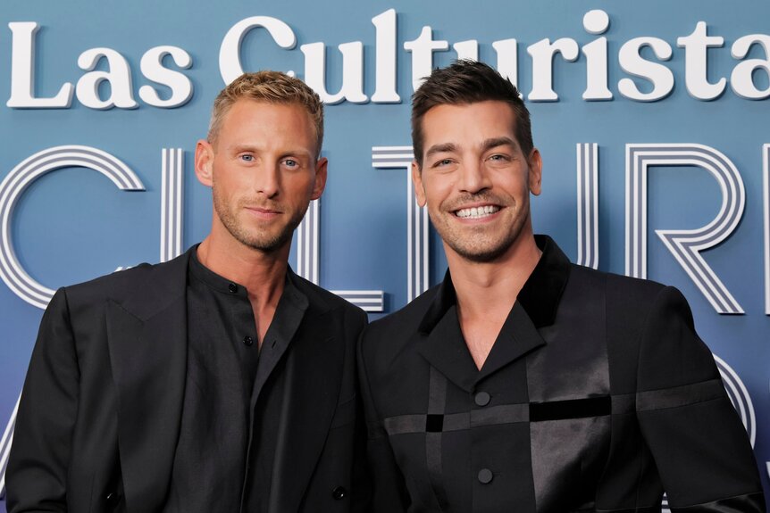 Fraser Olender and, boyfriend, Matt Rogers smiling and posing in front of a step and repeat.