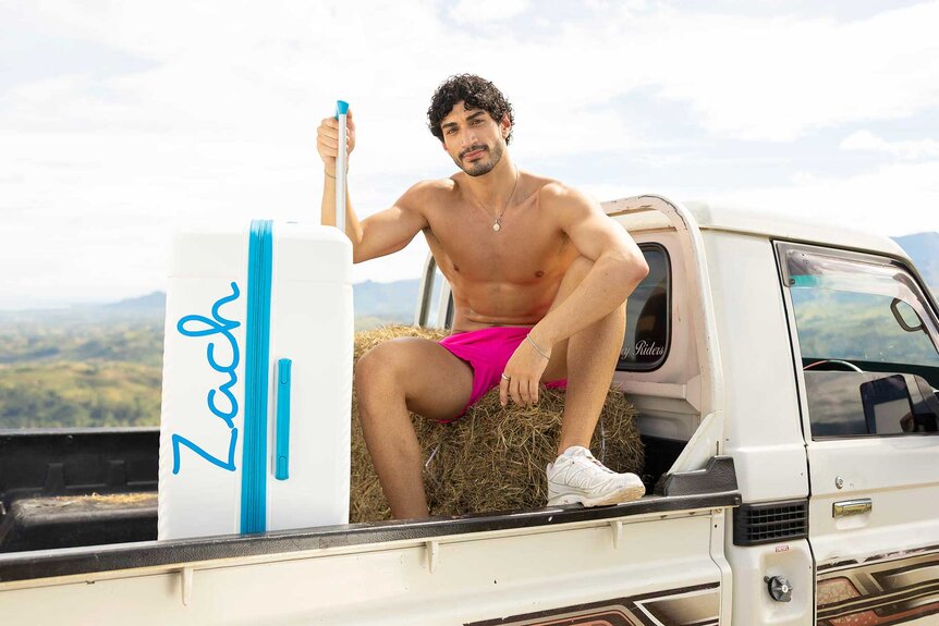 Zacharias Georgiou sitting on the back of a truck on Love Island USA Season 8.