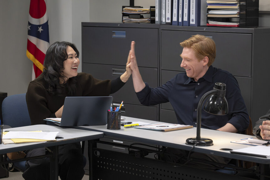 Nicole (Ramona Young) and Ned (Domhnall Gleeson) high fiving in The Paper Season 2 Episode 7.