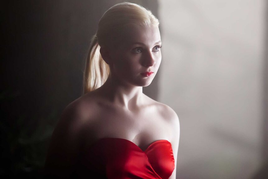 Veronica standing in a red dress in Final Girl (2015).