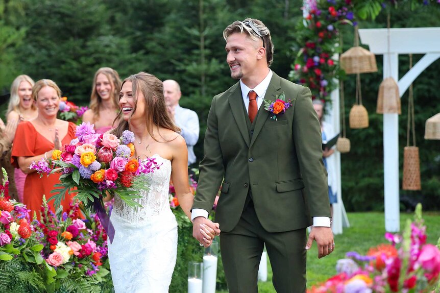 Caitlin Grimm and Devin Short holding hands while walking down the aisle on Married at First Sight Season 20 Episode 1.