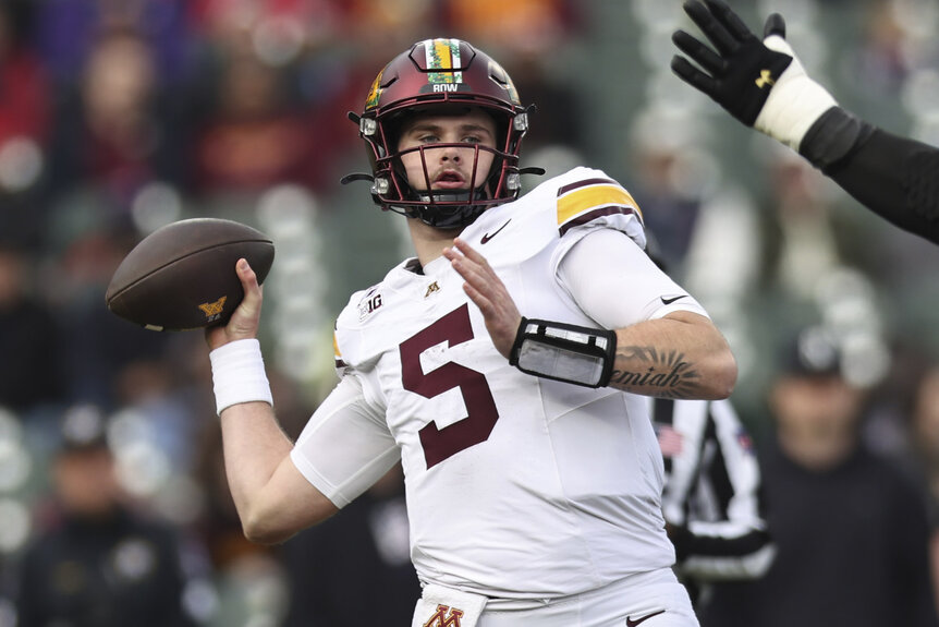 Drake Lindsey, #5 of the Minnesota Golden Gophers, preparing to throw a football.