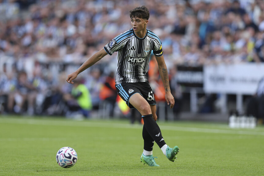 Lewis Miley of Newcastle United kicking a soccer ball during a match.
