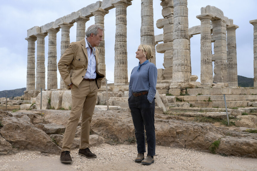 Neville (Hugh Laurie) and Elise (Amy Poehler) stand at a historical site in Dig Season 1.