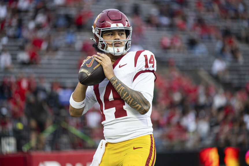 Jayden Maiava, #14 of the USC Trojans, throwing a football ahead of a game.