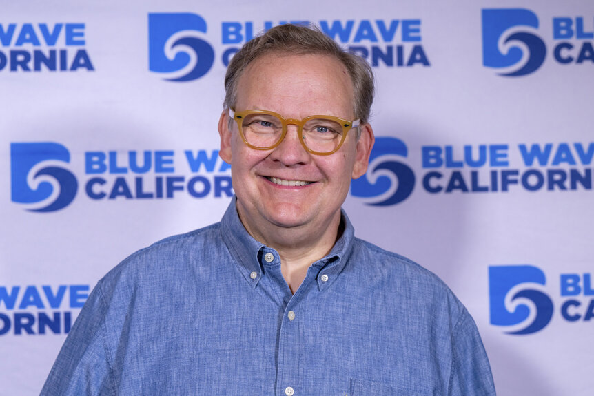Andy Richter posing in front of a step and repeat.