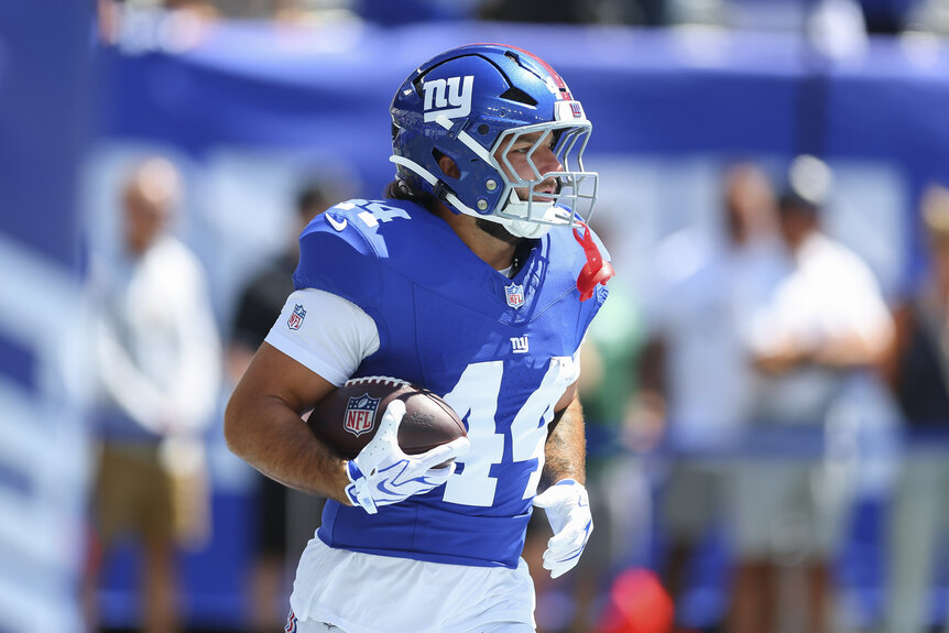 Cam Skattebo, #44 of the New York Giants, running with a football ahead of a game.